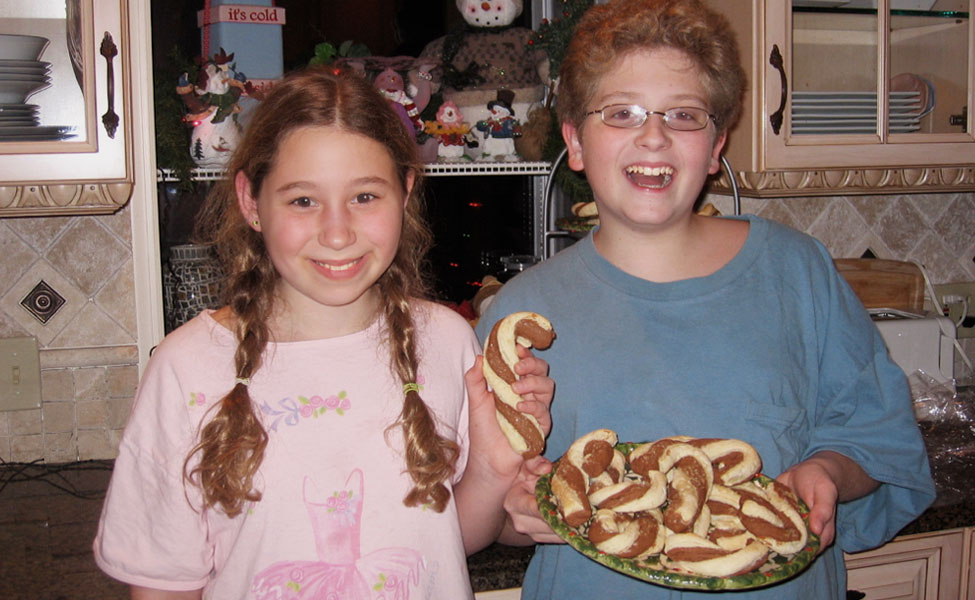 boy and girl holding a plate of Boardwalk Chocolate Pretzels shaped like candy canes